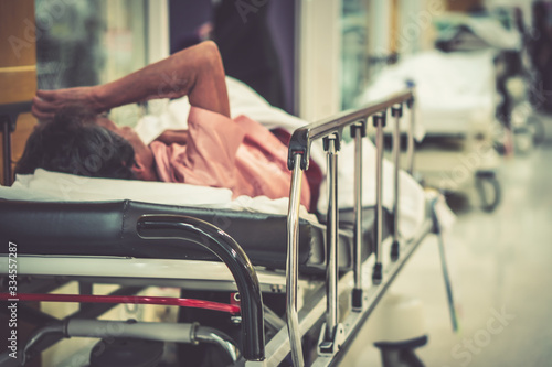 Blur hospital Background with old elder patient on bed and wheelchair waiting hallway ward. Poor healthcare treatment service for illness  sick people with support from professional nurse and doctor