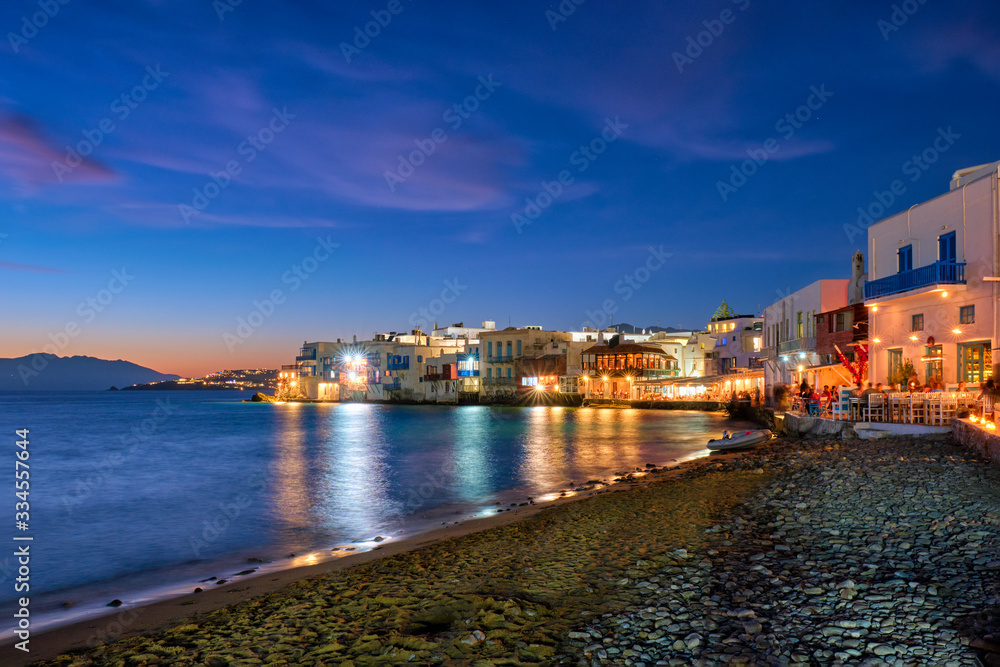 Harbor and colorful waterfront houses of Little Venice romantic spot illuminated in night. Mykonos townd, Greece