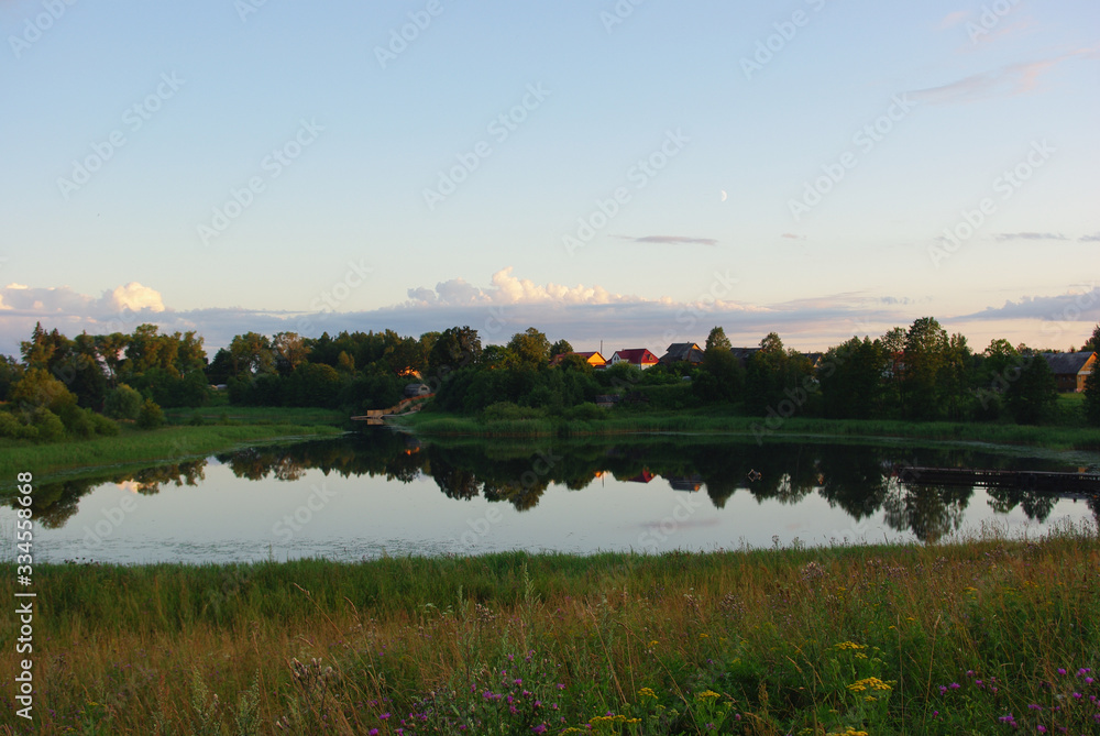 Pacified landscape of the Russian countryside including small pond. Tver region, Central Russia. Summer evening.
