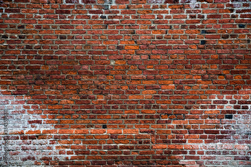 A rustic and textured, full frame brick wall background that is textured, worn, weathered, old, vintage and rough with a grunge look and copy space