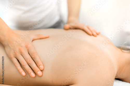 Body care hands detail.  Young athlete girl having a back massage, relaxing in spa salon, © Milan