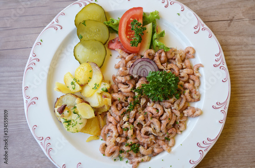 north sea crabs with fried potatoes and parsley garnish, the aromatic seafood is a typical delicacies on the coast in friesland, northern germany, high angle view from above