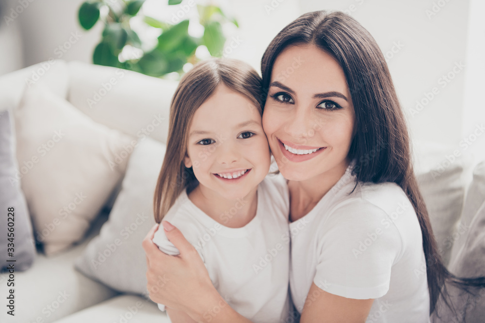 Close up photo of positive cheerful two people mom and small daughter enjoy spend free time together hug embrace in room apartment Close up photo of positive cheerful two people mom and small daughter enjoy spend free time together hug embrace in room apartment