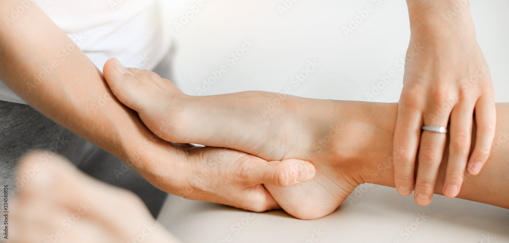Professional therapist giving relaxing leg massage treatment to athlete woman in therapy centre. Professional therapist giving relaxing leg massage treatment to athlete woman in therapy centre.