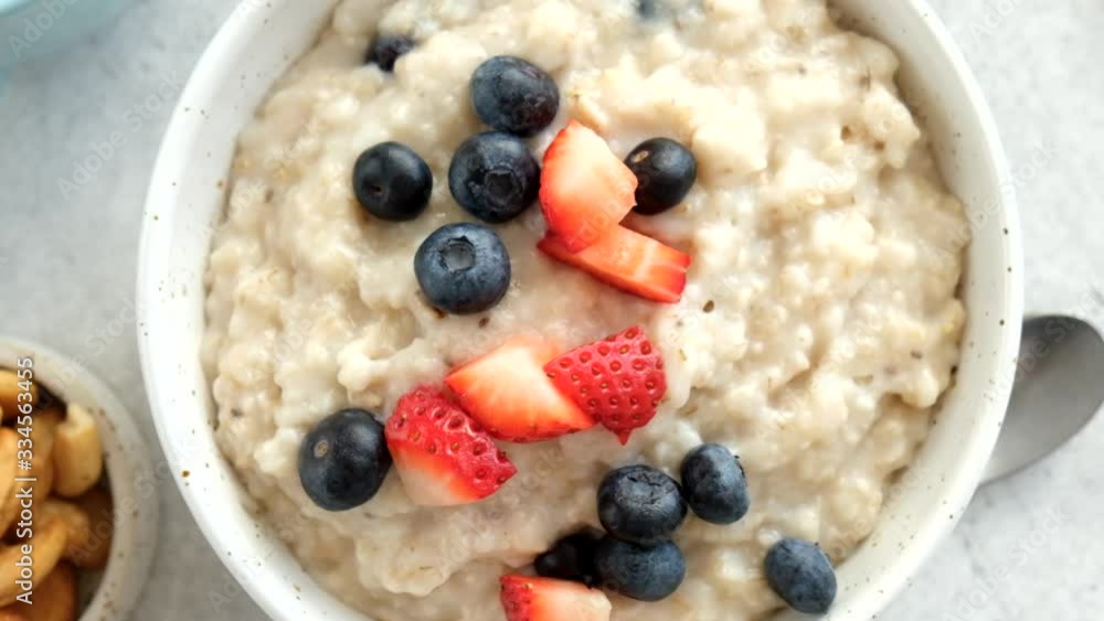 Oatmeal porridge with summer berries in bowl and cup of black coffee on table. Top view Oatmeal porridge with summer berries in bowl and cup of black coffee on table. Top view