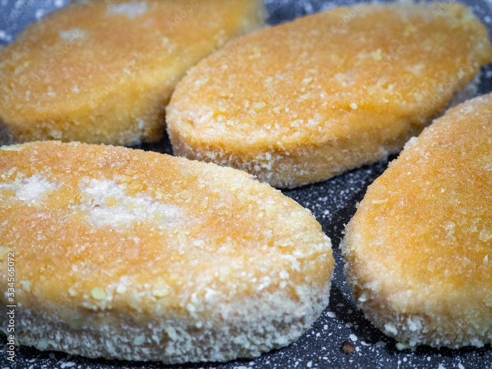 Fish cutlets in a pan close-up. The breading on the rissole became ruddy. Background with freshly cooked  cutlets