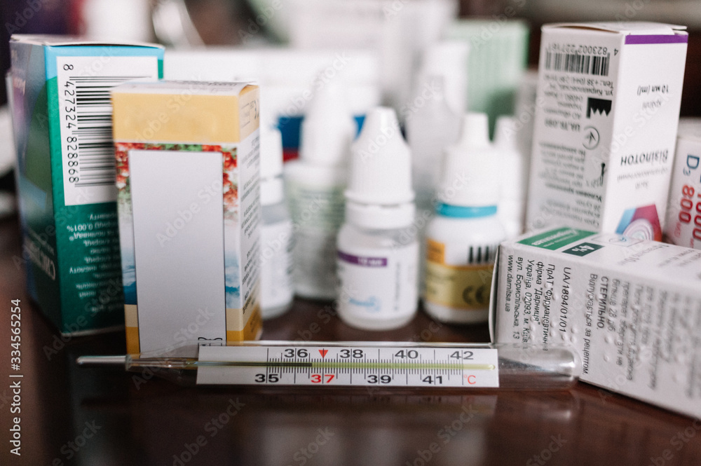 medications and thermometer for the treatment of coronavirus on the table