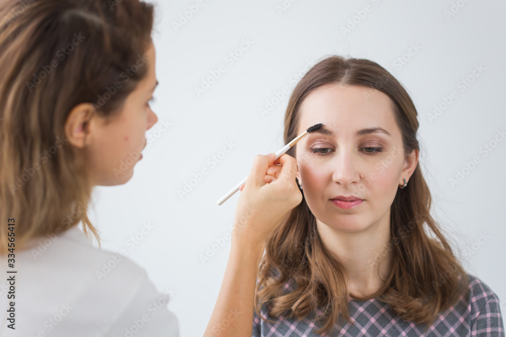 Beauty and cosmetics concept - Makeup artist doing professional make up of young woman Beauty and cosmetics concept - Makeup artist doing professional make up of young woman