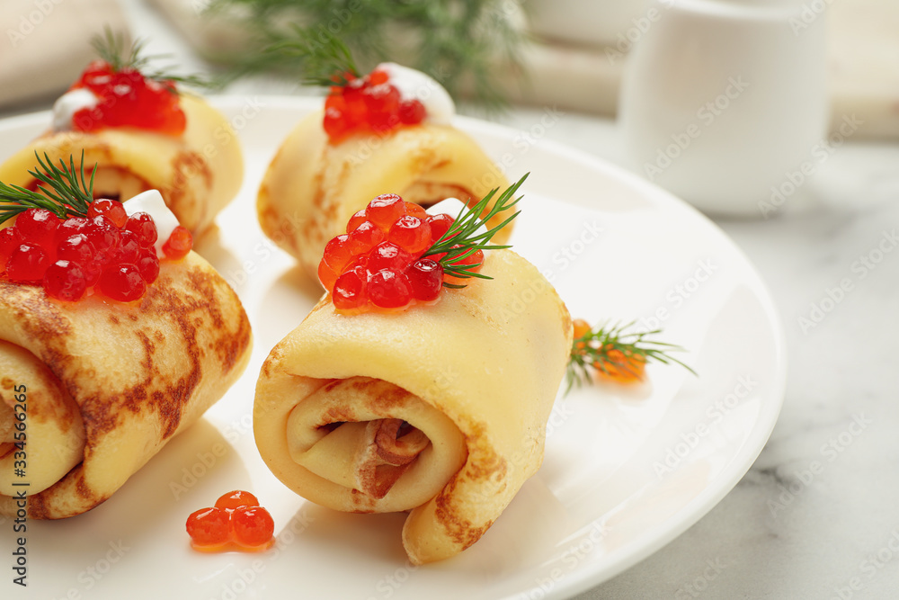 Delicious thin pancakes with red caviar on plate, closeup Delicious thin pancakes with red caviar on plate, closeup