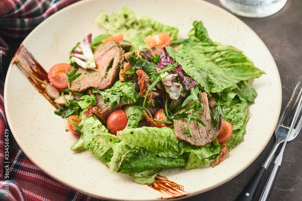 Warm salad with beef, cherry tomatoes and sun-dried tomatoes. Healthy food Warm salad with beef, cherry tomatoes and sun-dried tomatoes. Healthy food