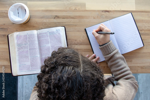 top view of woman journaling as she reads and works on a bible study