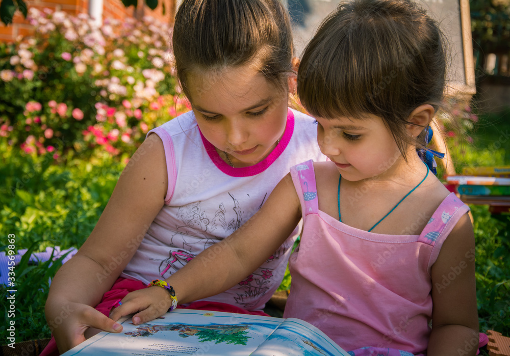 Fototapeta premium two girls looking at a book