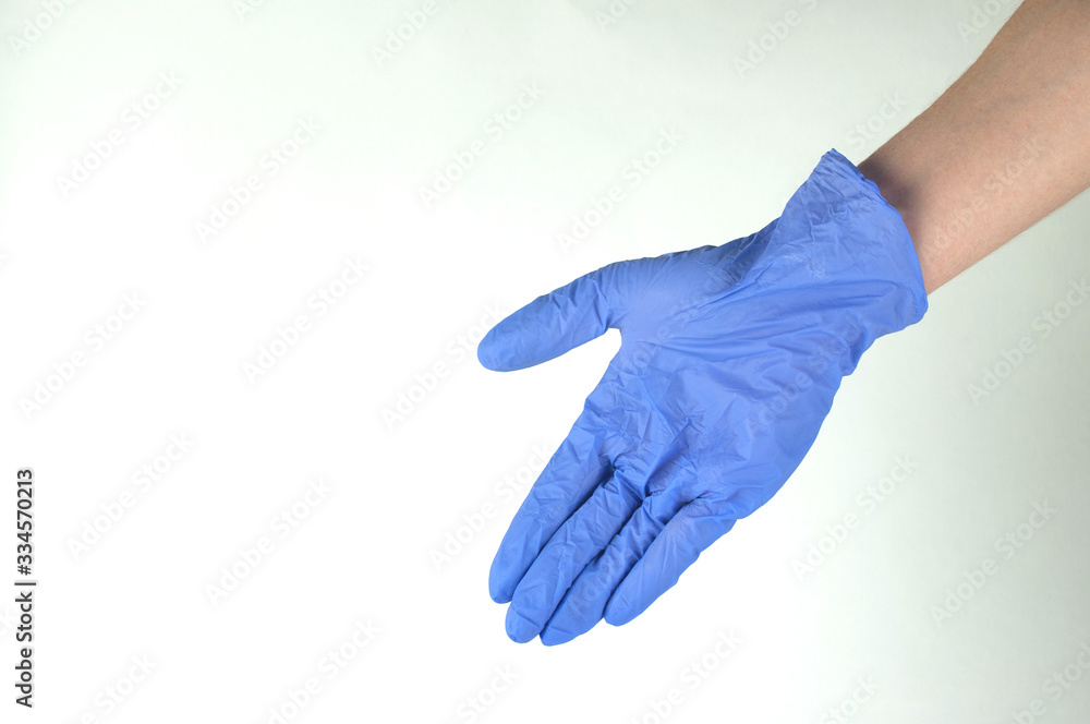 a woman's hand in a blue glove, a concept of protection against coronavirus