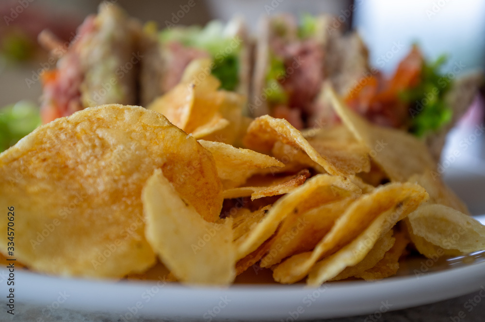 Sandwiches, ham salad with potato chips in foreground Sandwiches, ham salad with potato chips in foreground