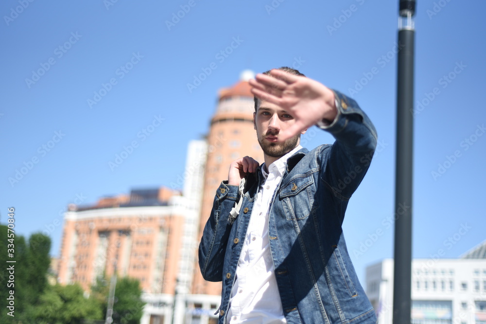 Young man covers part of his face with his palm Young man covers part of his face with his palm