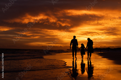 silhouette of family on beach at sunset