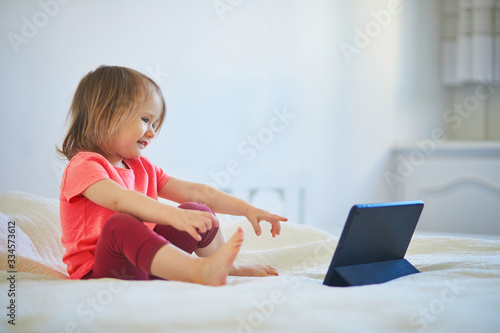 Toddler girl with digital tablet at home