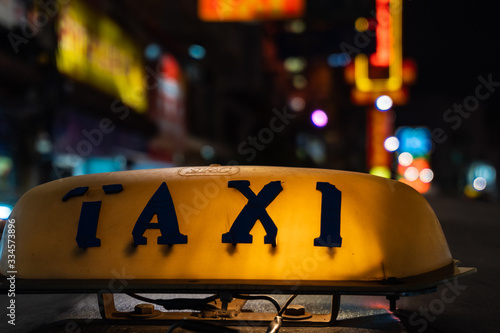 Old taxi sign glowing in the dark, streets of Bangkok © Vitali