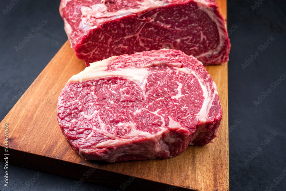 Raw dry aged wagyu entrecote beef steak roast as top view on a modern design wooden board Raw dry aged wagyu entrecote beef steak roast as top view on a modern design wooden board