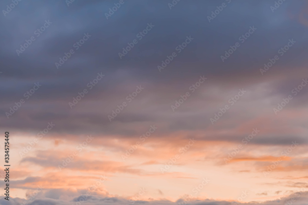 Beautiful orange, yellow and pink clouds in the blue sky. Background. Copy space.
