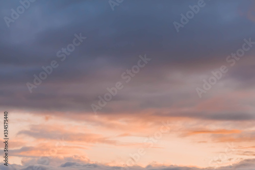 Beautiful orange, yellow and pink clouds in the blue sky. Background. Copy space.