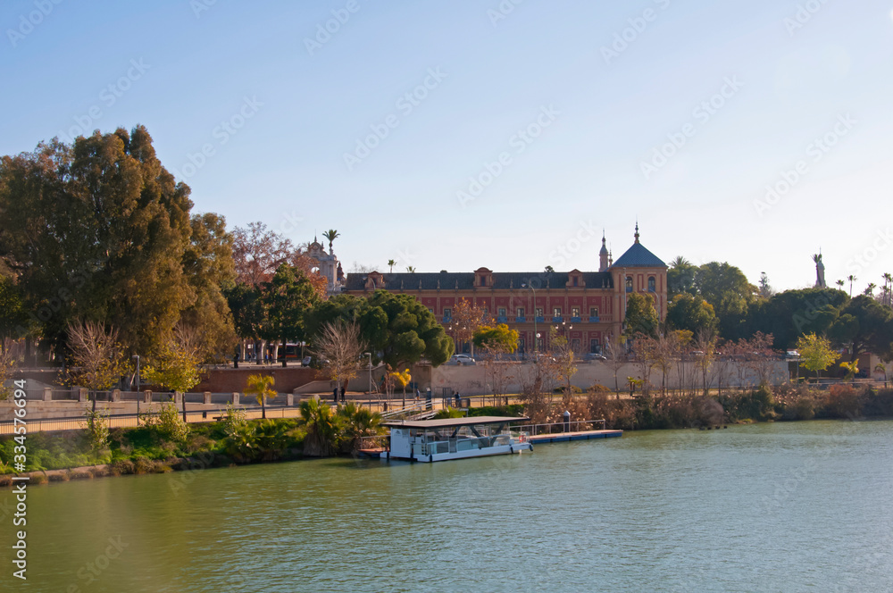 Obraz premium Summer pleasure boat on the river, San Telmo palace. Seville, Spain