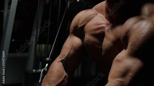  Bodybuilder shakes muscles in the gym. 