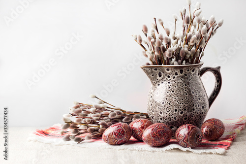 Still life with pysanka and willow branches in jug