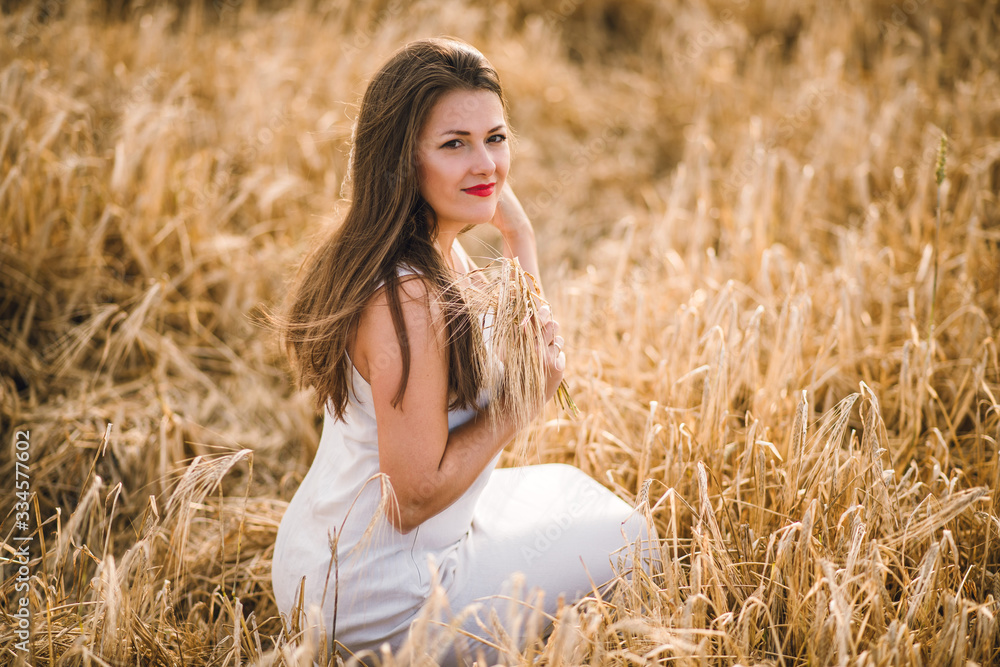 beautiful girl with brunette hair on a wheat field background. warm summer time. beautiful girl with brunette hair on a wheat field background. warm summer time.