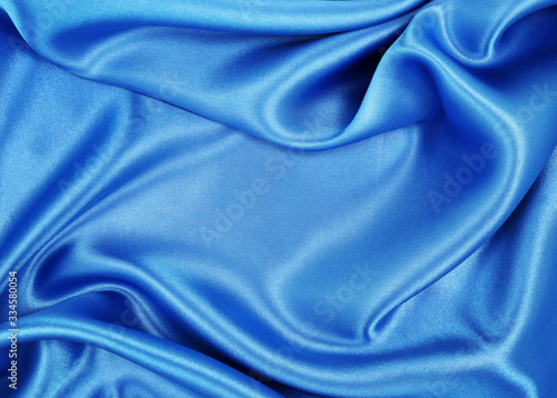 Smooth elegant blue silk or satin luxury cloth texture as abstract background. Luxurious background design