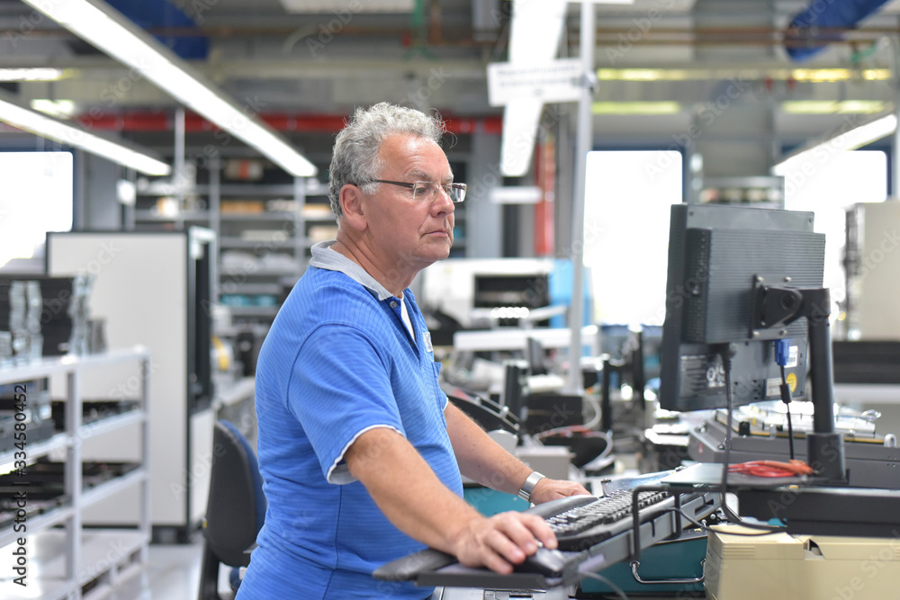engineering in microelectronics: senior workers in the production and assembly of electronic high tech components in a modern factory engineering in microelectronics: senior workers in the production and assembly of electronic high tech components in a modern factory