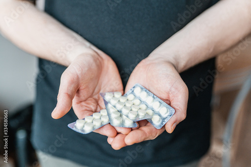 Close-up of men's hands holding a blister with pills