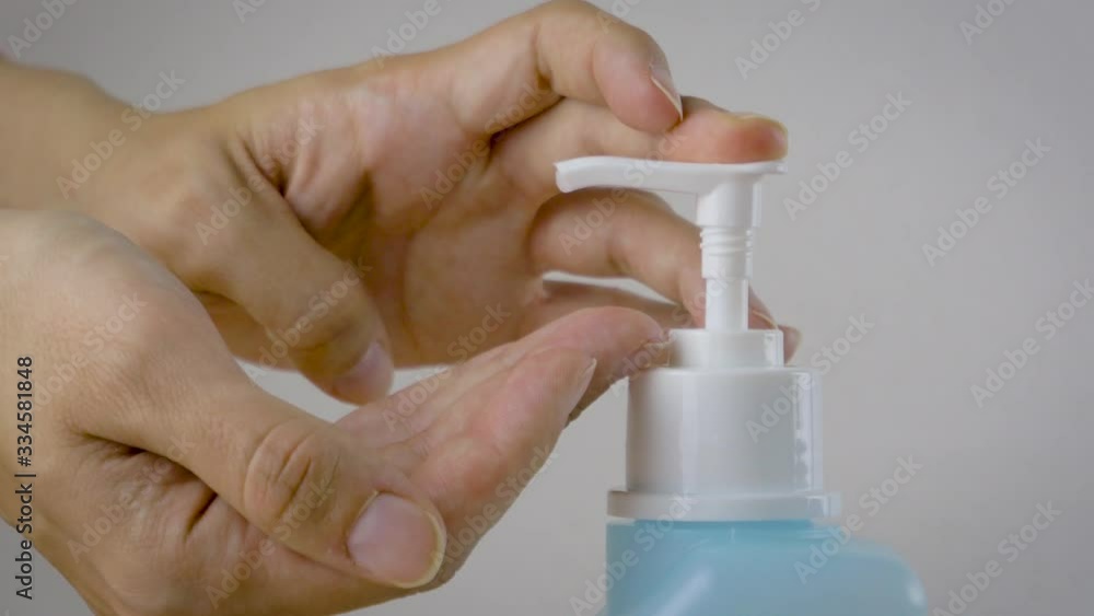 A woman is disinfecting hands rubbing with a sanitizer for corona virus prevention, hygiene to stop spreading coronavirus. Concept of early healthy hygiene learning and disease spreading prevention. A woman is disinfecting hands rubbing with a sanitizer for corona virus prevention, hygiene to stop spreading coronavirus. Concept of early healthy hygiene learning and disease spreading prevention.