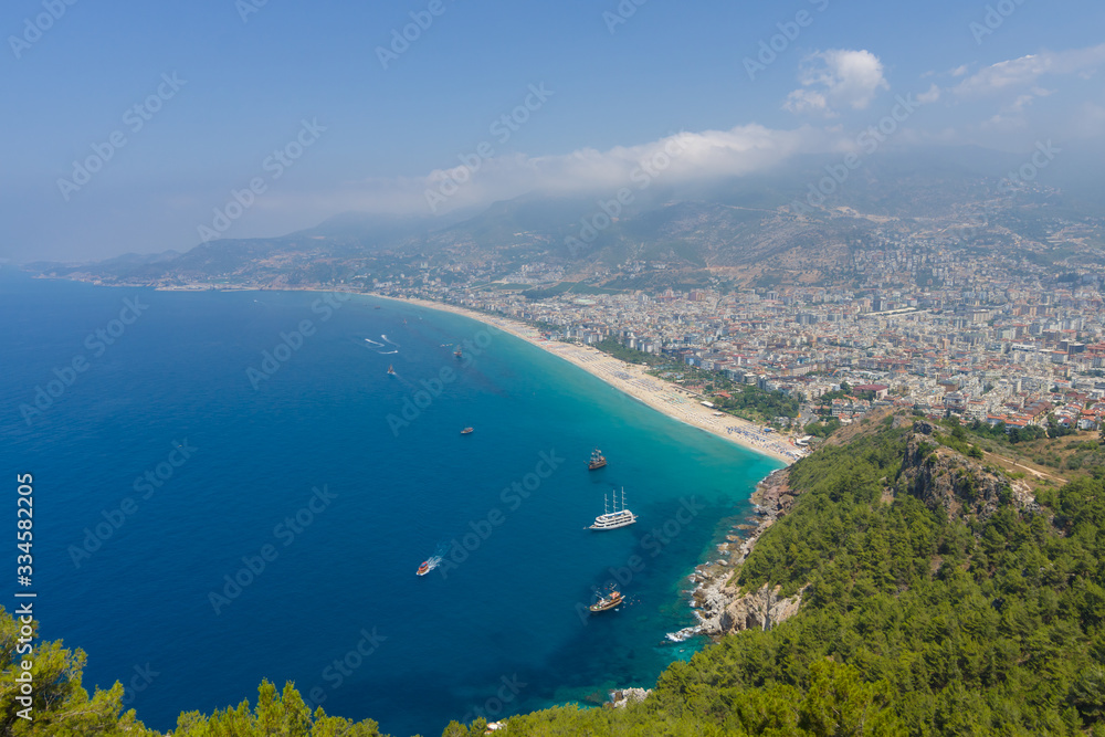 Alanya. Turkey. The city beach in Alanya. The coastline is receding into the distance. The view from the bird's eye view. Alanya - a popular holiday destination for European tourists.