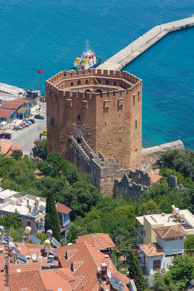 Alanya. Turkey. Red Tower (Kizil Kule) and the ruins of the fortress wall.