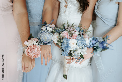 Bride and bridesmaids hand with beautiful flowers. Bridesmaids have control over bouquets