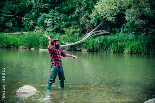 Elegant bearded brutal hipster man fishing. Fish on hook. Catch me if you can. Nice day for fishing. Keep calm and fish on. Fisherman with fishing rod. Handsome fisherman.