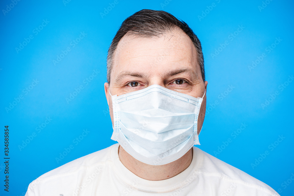 Headshot of an adult Caucasian man wearing aseptic facial mask to prevent virus contamination. COVID-19 or coronavirus protection. Headshot of an adult Caucasian man wearing aseptic facial mask to prevent virus contamination. COVID-19 or coronavirus protection.