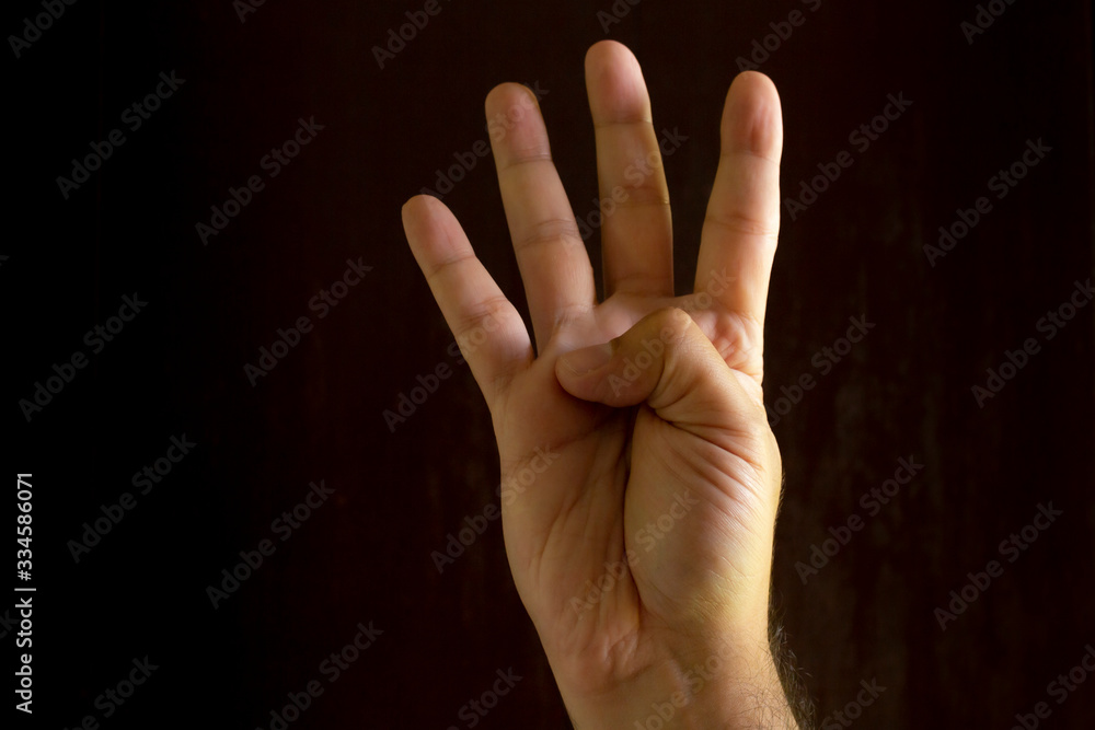 Man hand on black background. Gesture language with the hands. Non-verbal communication concept. Man hand on black background. Gesture language with the hands. Non-verbal communication concept.