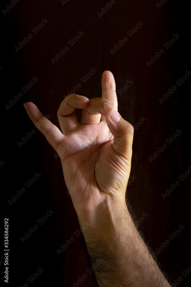 Man hand on black background. Gesture language with the hands. Non-verbal communication concept. Man hand on black background. Gesture language with the hands. Non-verbal communication concept.