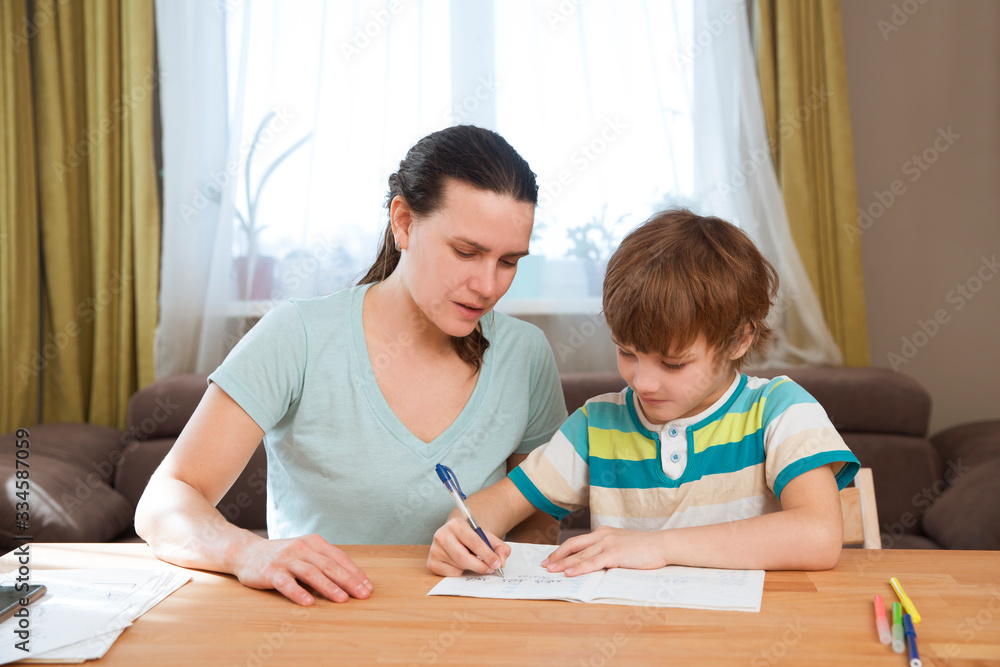 Mom helps child boy do lessons at home. kid study at home. quarantine. Corona Virus. Mom helps child boy do lessons at home. kid study at home. quarantine. Corona Virus.