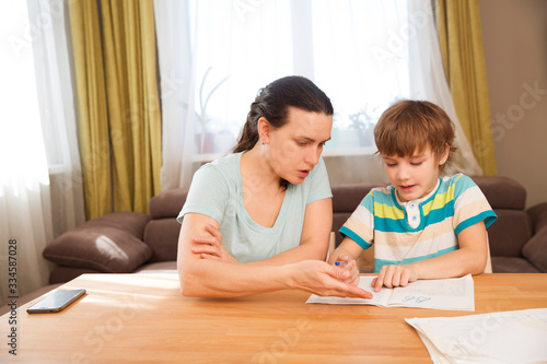 Mom helps child boy do lessons at home. kid study at home. quarantine. Corona Virus. 