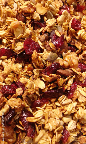 Homemade granola with nuts and dried berries closeup. Toasted oatmeal granola or muesli texture background. 