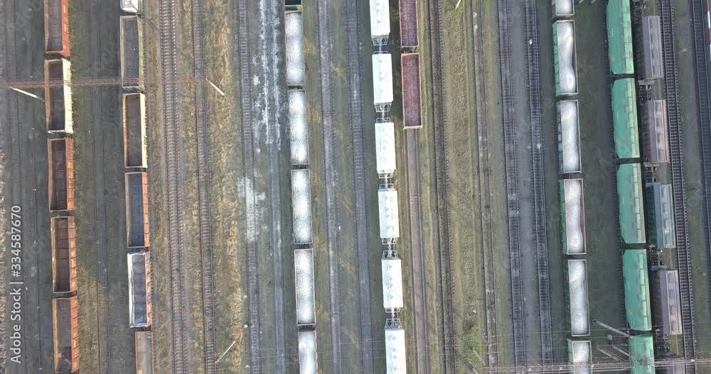 Cargo trains close-up. Aerial view of colorful freight trains on the railway station. Wagons with goods on railroad. Heavy industry. Industrial conceptual scene with trains. Top view from flying drone Cargo trains close-up. Aerial view of colorful freight trains on the railway station. Wagons with goods on railroad. Heavy industry. Industrial conceptual scene with trains. Top view from flying drone