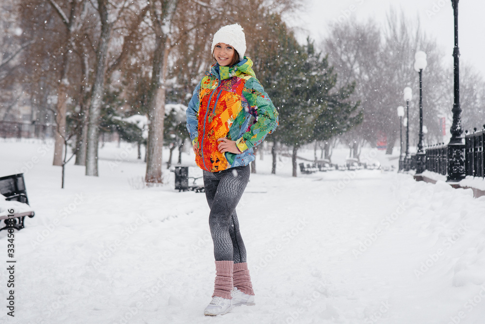 A young athletic girl poses on a frosty and snowy day. Fitness, running A young athletic girl poses on a frosty and snowy day. Fitness, running