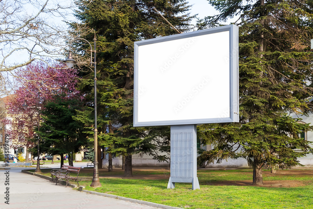 Blank billboard mockup with copy space in a pablic park on a spring day. Empty banner for advertisement. Large white screen for your text. Blank billboard mockup with copy space in a pablic park on a spring day. Empty banner for advertisement. Large white screen for your text.