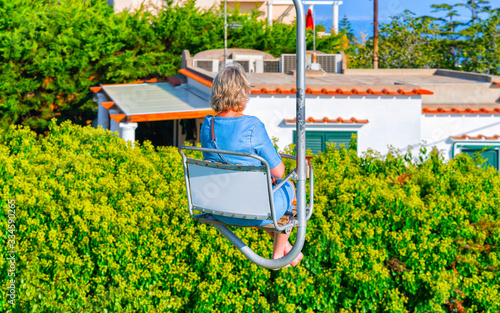 Woman on funicular cable chair above Capri Island reflex