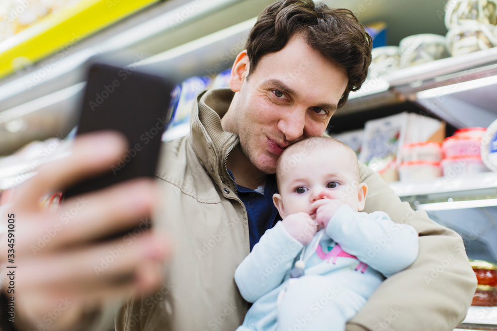 Affectionate father and baby daughter taking selfie in supermarket Affectionate father and baby daughter taking selfie in supermarket