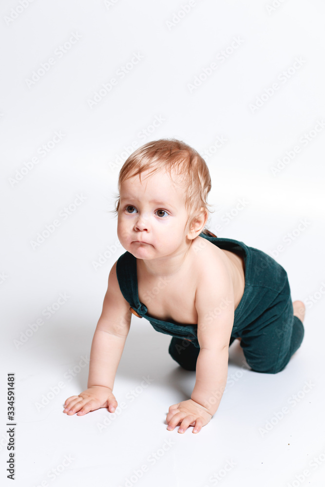 A one-year-old boy in a green jumpsuit A one-year-old boy in a green jumpsuit