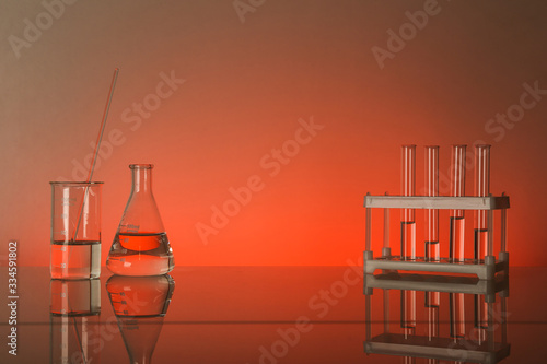 conceptual background with chemical flasks. red backdrop with lab glassware with copy space. conceptual background of chemistry science in laboratory © Петр Смагин